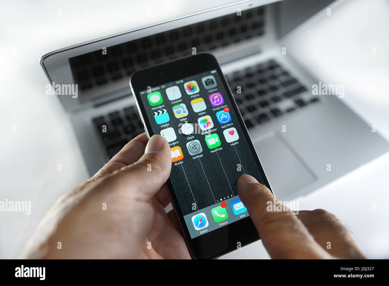 Montreal, Canada, 7 July, 2017. Hands holding an iphone 6 on top of a Macbook Air.Credit:Mario Beauregard/Alamy Live News Stock Photo