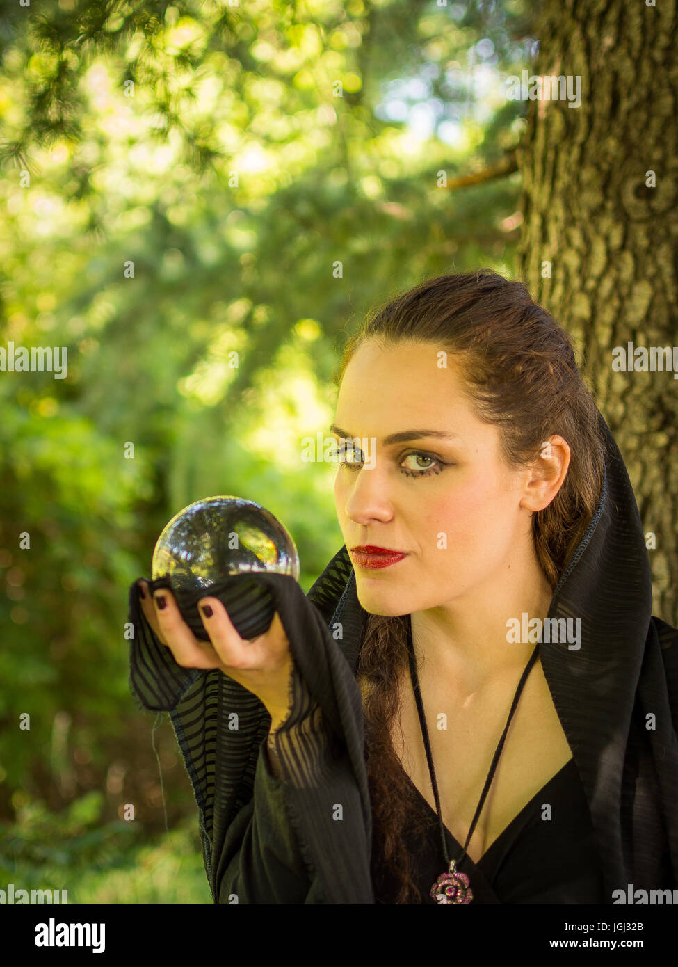 Woman in dark dress with crystal ball in the forest Stock Photo - Alamy