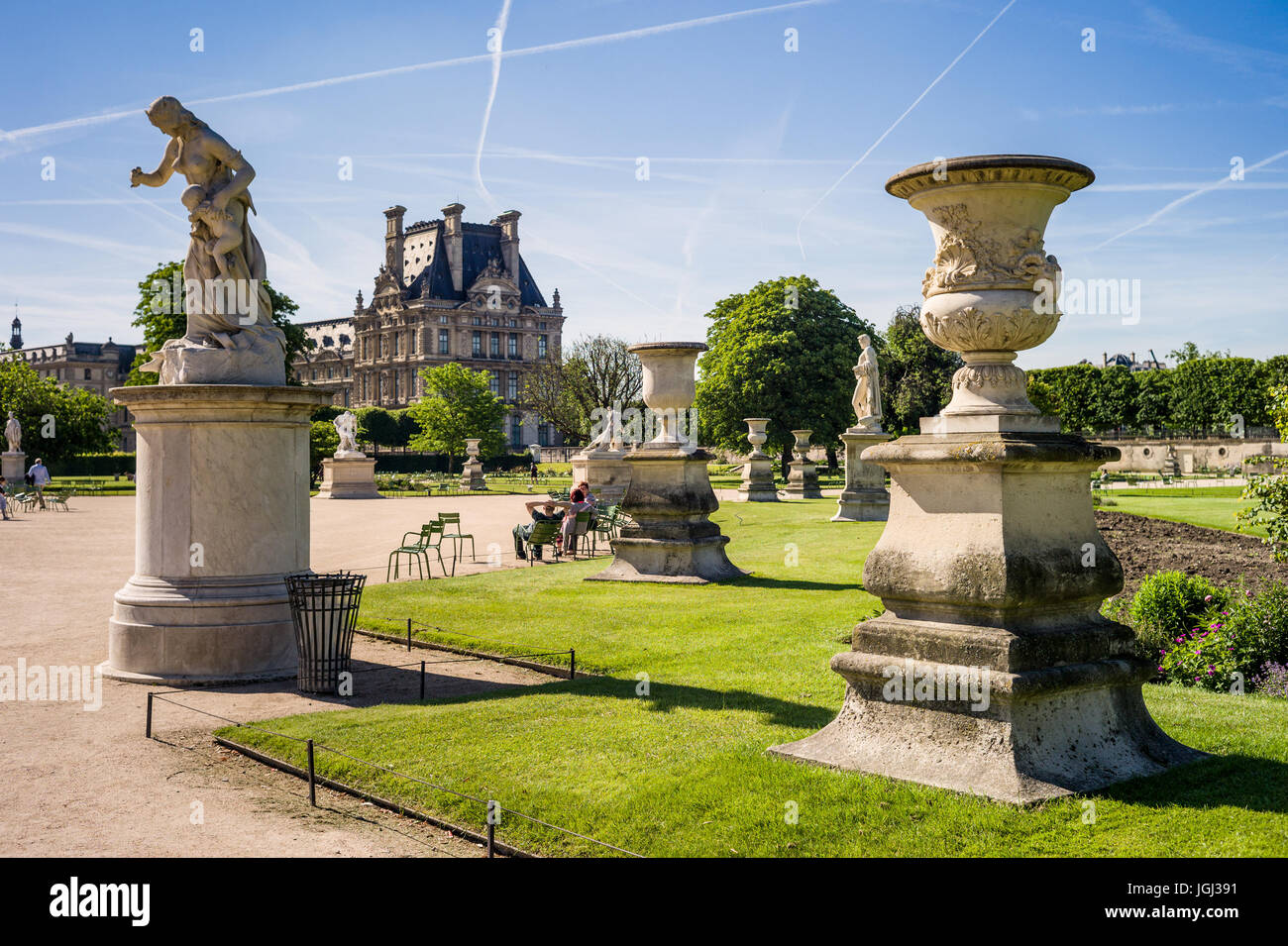 The Tuileries garden in Paris, France, by a sunny morning with the statue of Medea and a carved vase and the Flore pavilion of the Louvre palace. Stock Photo
