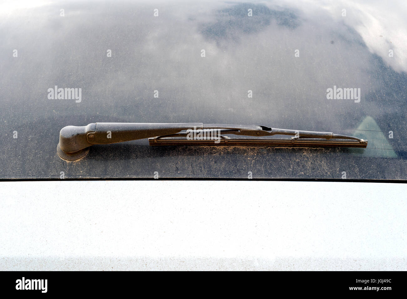 Dust covered rear windscreen wiper on a metallic blue car Stock Photo