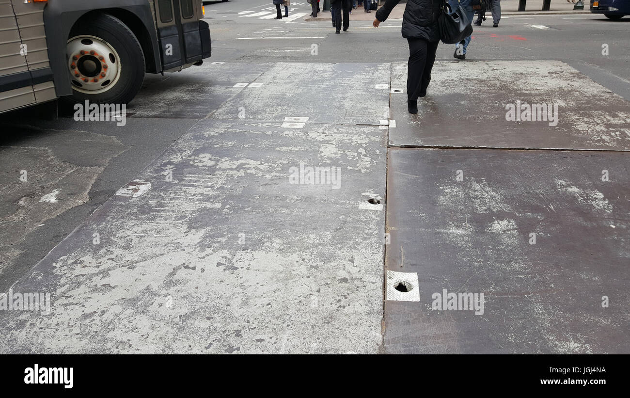 New York City under construction work in progress steel street covers bus wheel people walking Stock Photo