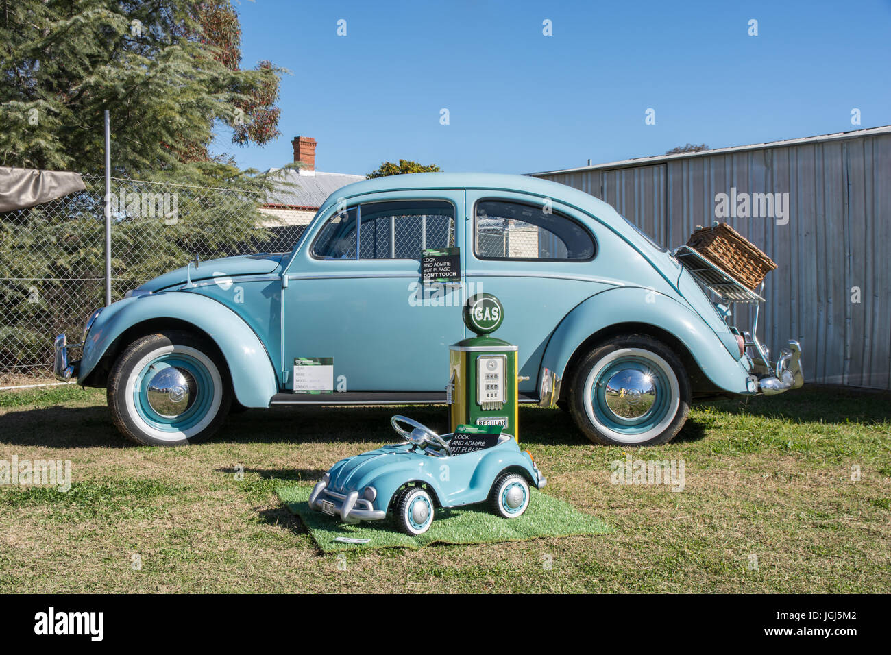A Restored 1961 Volkswagen Beetle on display with a childs toy model VW and a small replica petrol bowser at Barraba Australia. Stock Photo