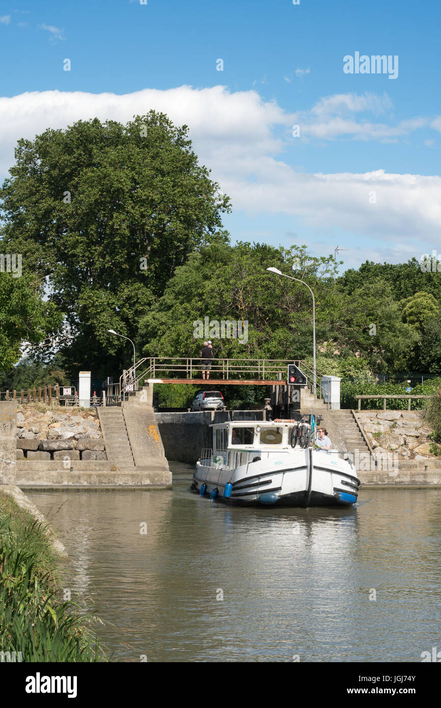 A boat leaving a lock on the Canal du Midi near Beziers, France Stock Photo