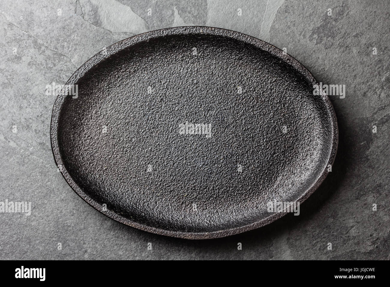 Food background. Empty cast iron black plate Stock Photo Alamy