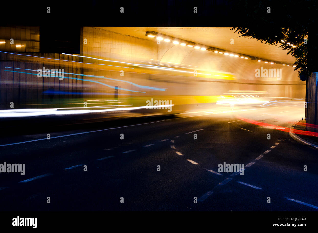 Night traffic on city streets. Vehicles getting in and out of the tunnel Stock Photo