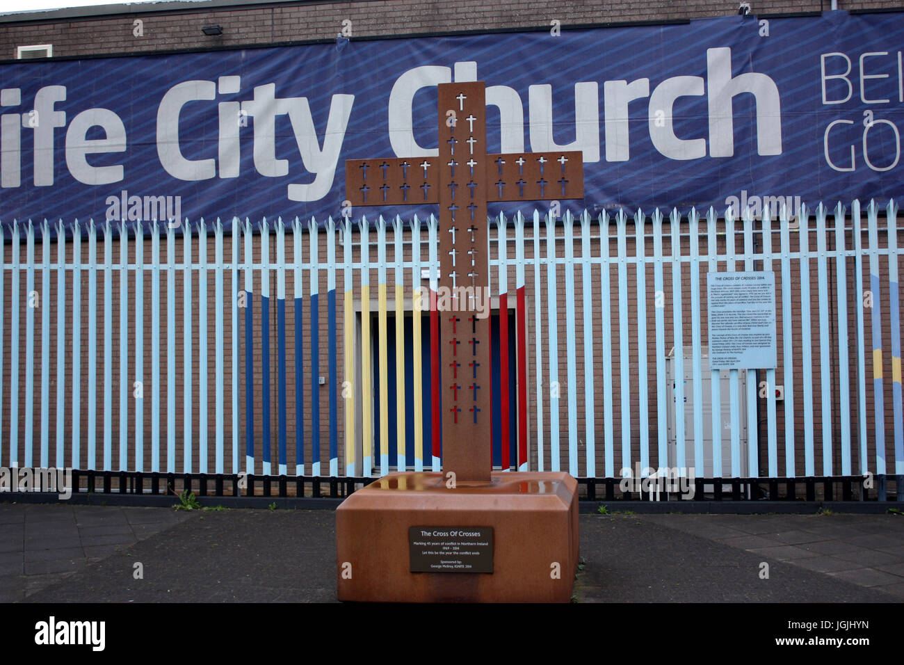 Cross between the armoured gates in West Belfast Stock Photo