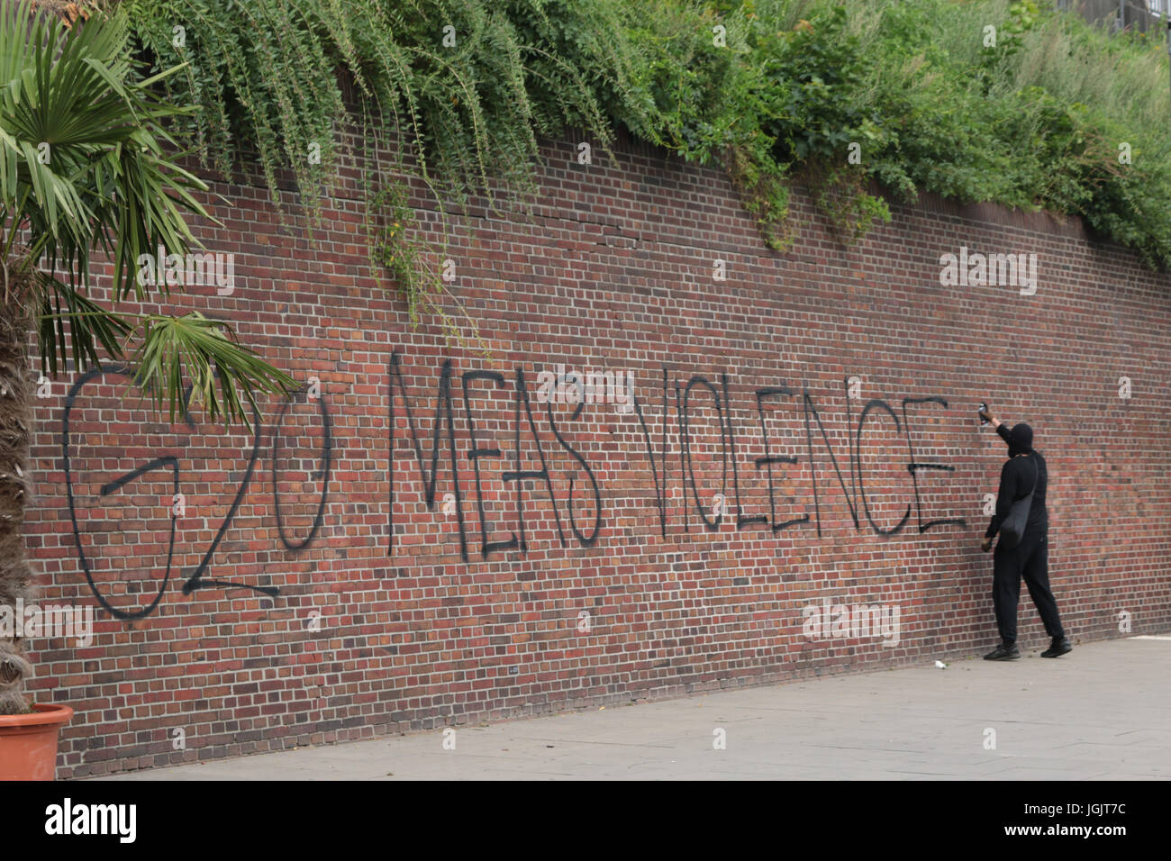 Hamburg, Germany. 07th July, 2017. G20 Summit protests in Hamburg. A black bloc spraypaints anti g20 graffiti Credit: Conall Kearney/Alamy Live News Stock Photo