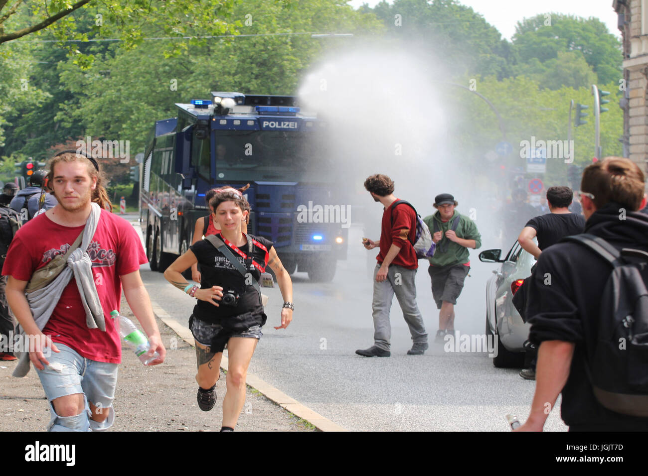 Hamburg, Germany. 07th July, 2017. G20 Summit protests in Hamburg. Protesters flee as watercannon opens fire Credit: Conall Kearney/Alamy Live News Stock Photo