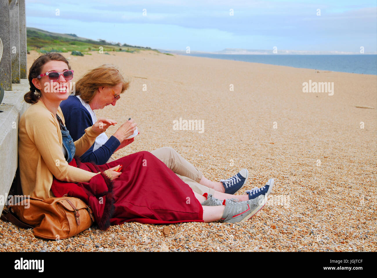 Chesil Beach, Dorset, UK. 7th July, 2017. Two women enjoy a picnic on
