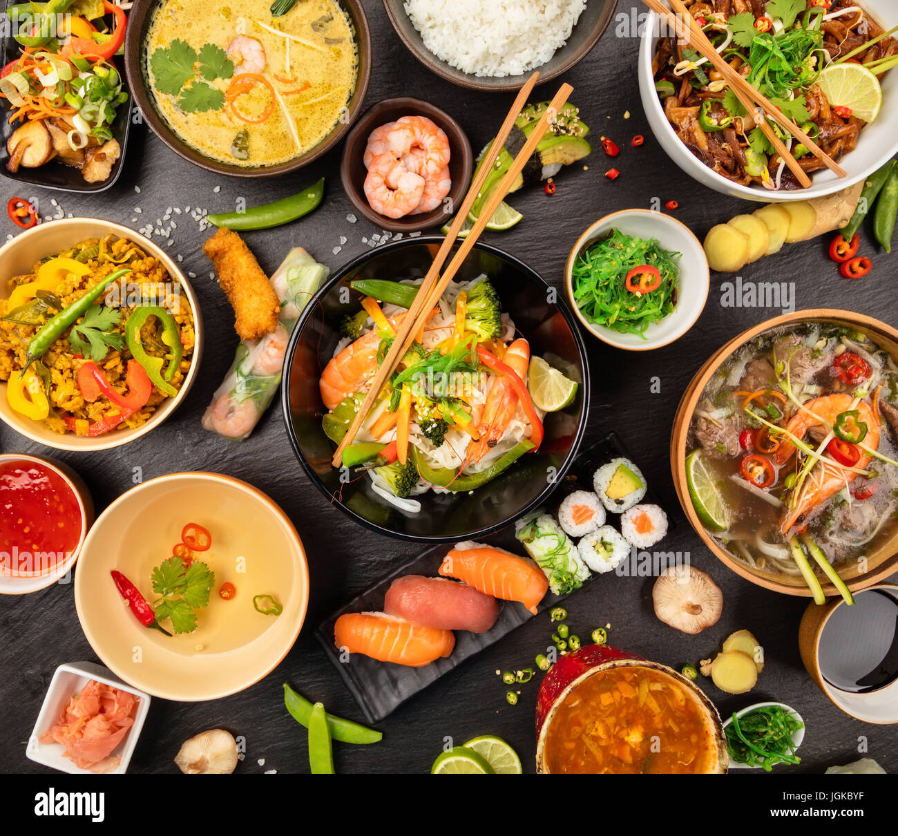 Asian food table with various kind of chinese food, noodles, chicken, pork,  beef, sour soup, rice, spring rolls, sushi, prawns and many others. Served  Stock Photo - Alamy