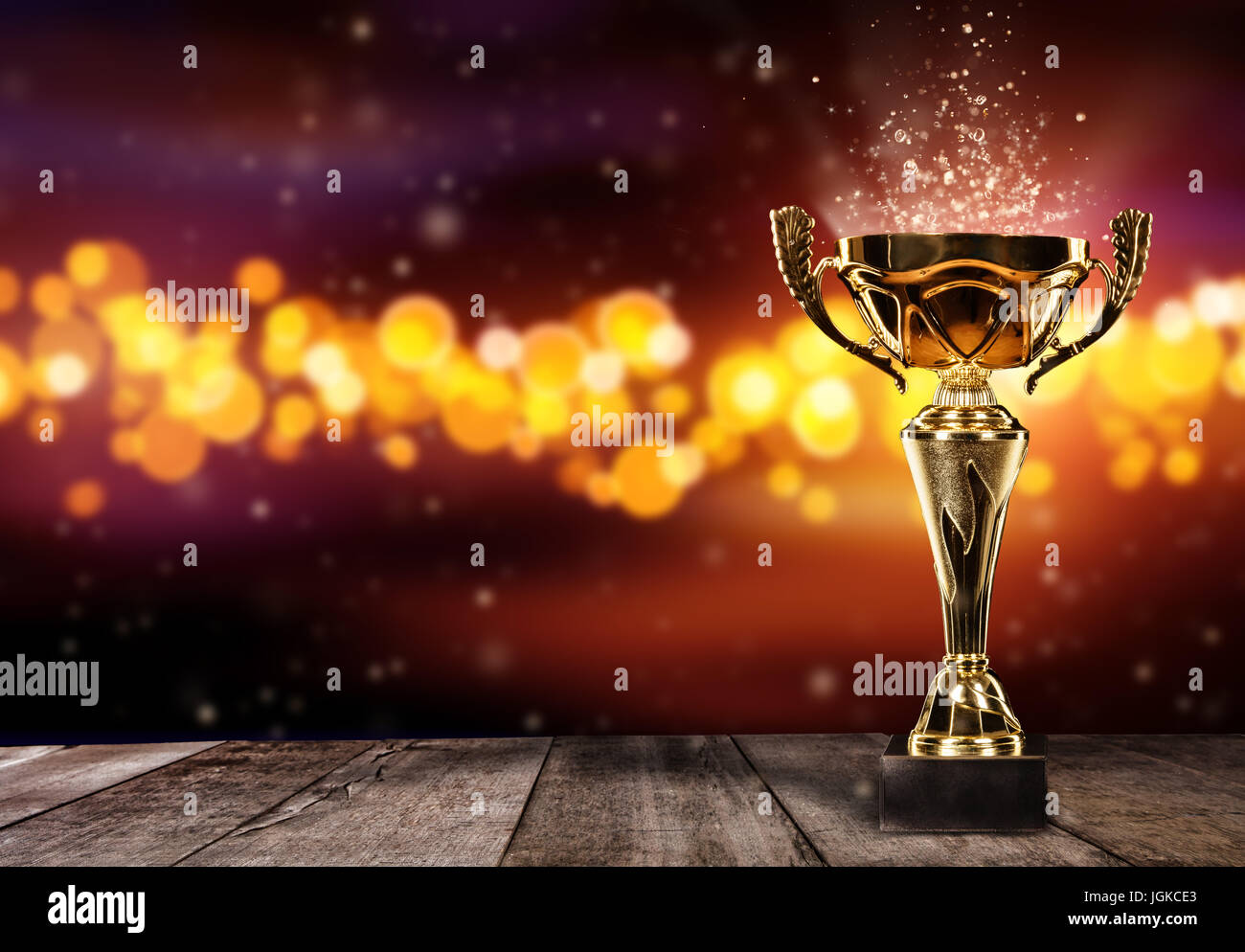 Champion golden trophy on wood table with blur spot lights on