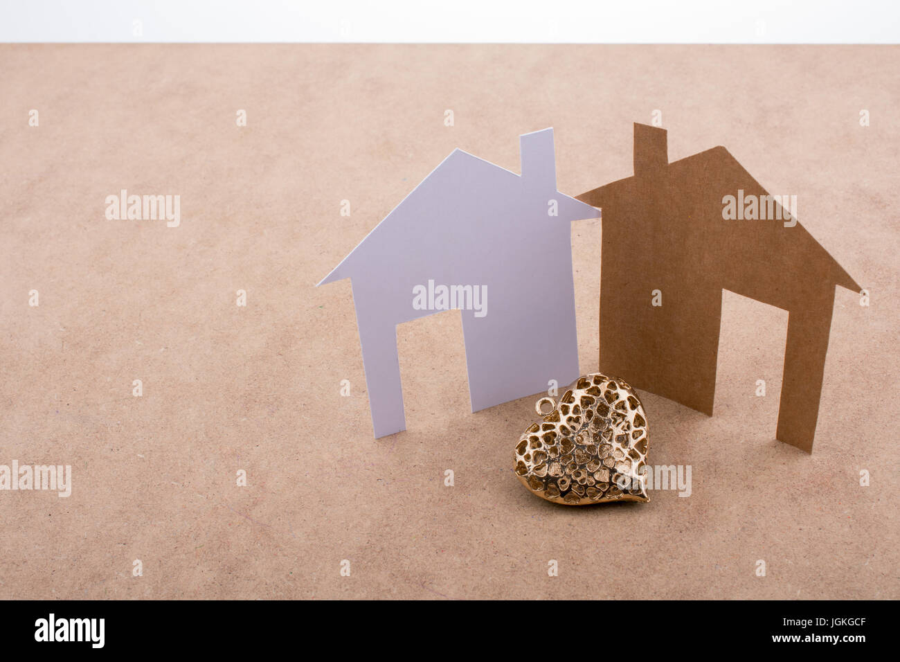 Heart shaped icon and paper houses on a brown background Stock Photo ...