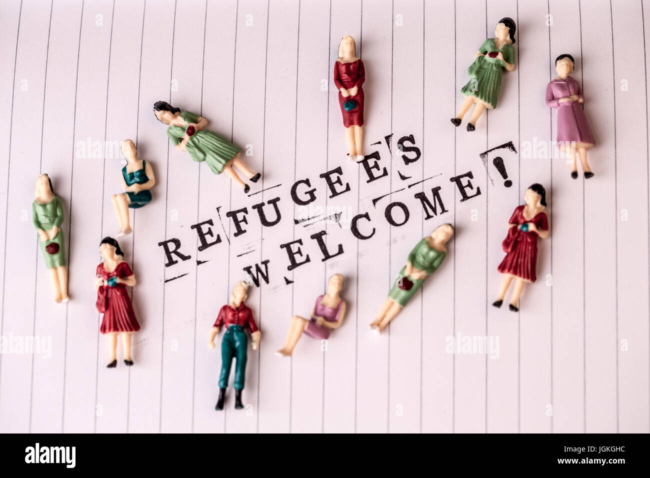 refugees welcome text on white line paper with woman figures around Stock Photo