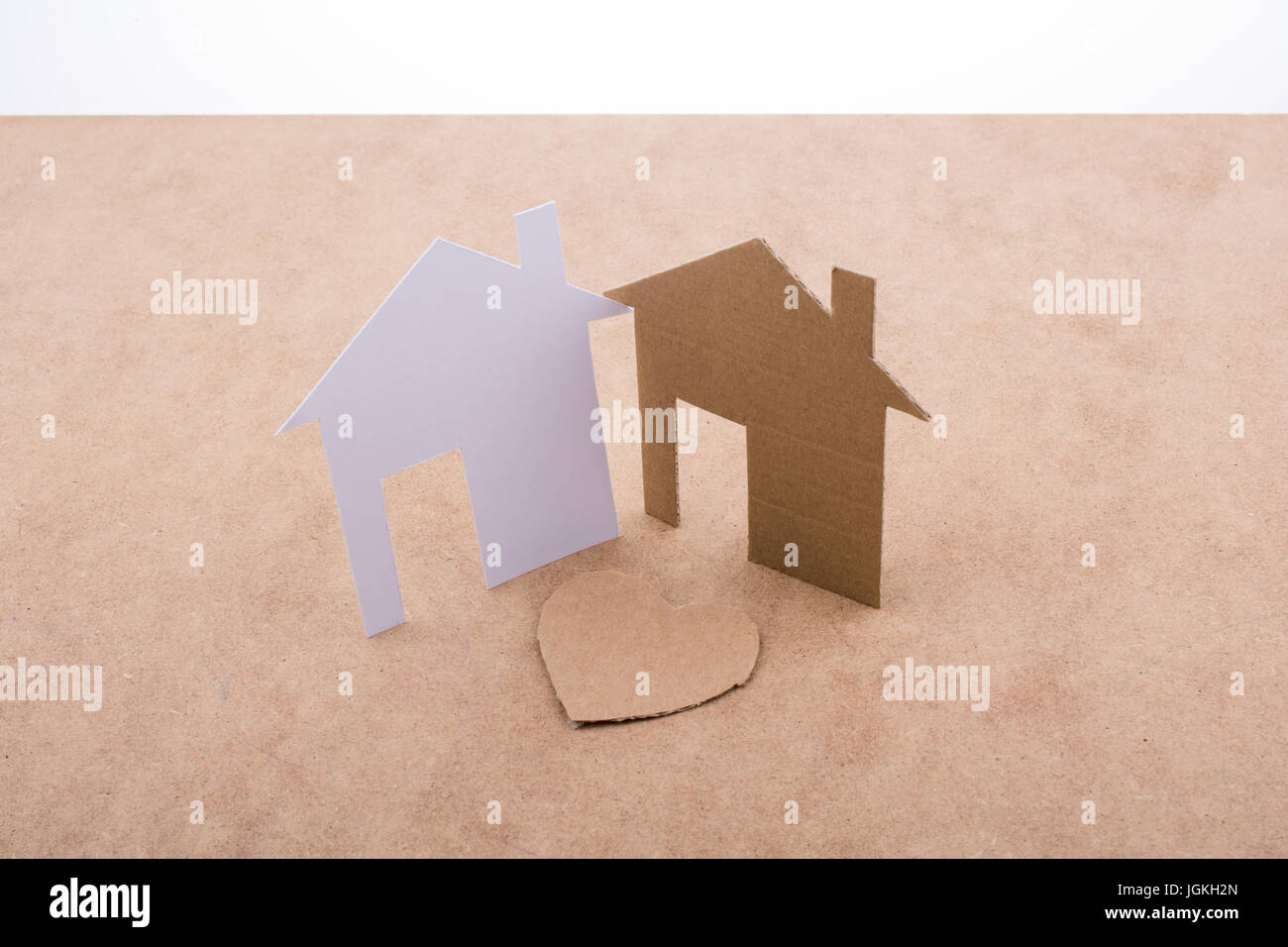 Heart shaped icon and paper houses on a brown background Stock Photo ...