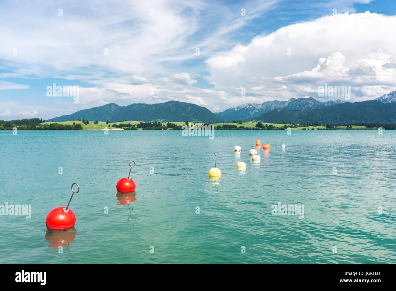 Marker buoys on surface of water. Mountains and thundery clouds. Stock Photo