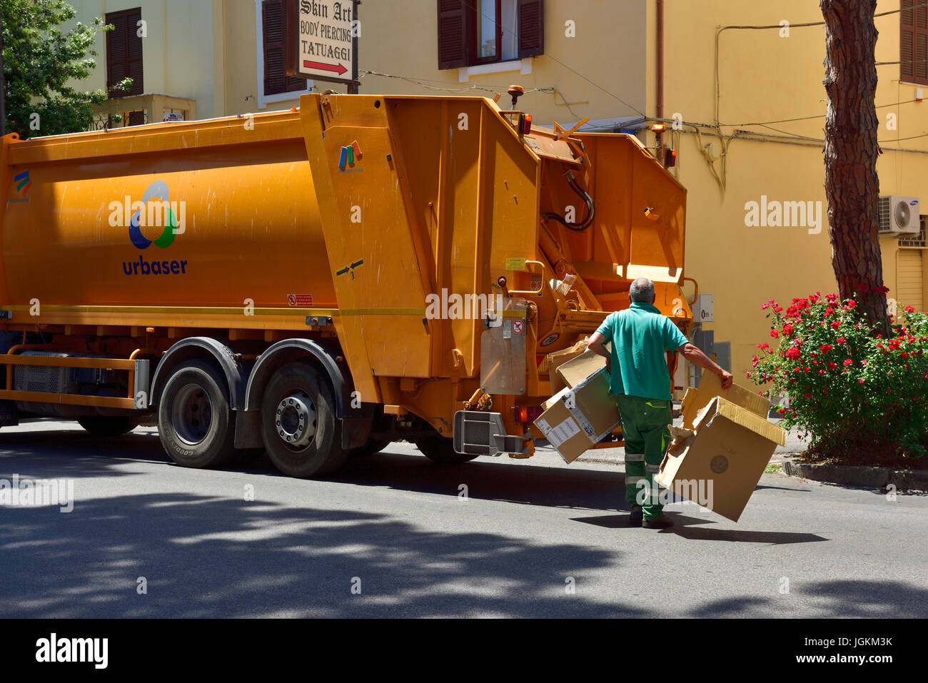 Recycling lorry with workman taking cardboard to it Stock Photo