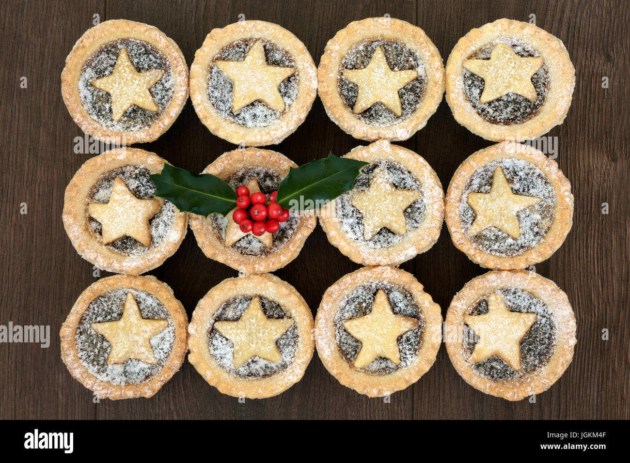 Christmas star mince pies with icing sugar dusting and holly on oak ...