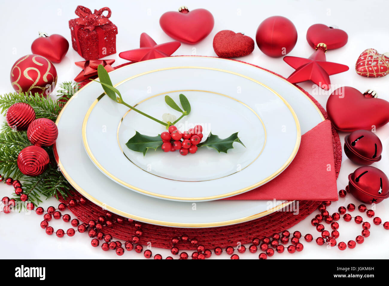 Christmas dinner table setting with porcelain plates, holly, mistletoe ...