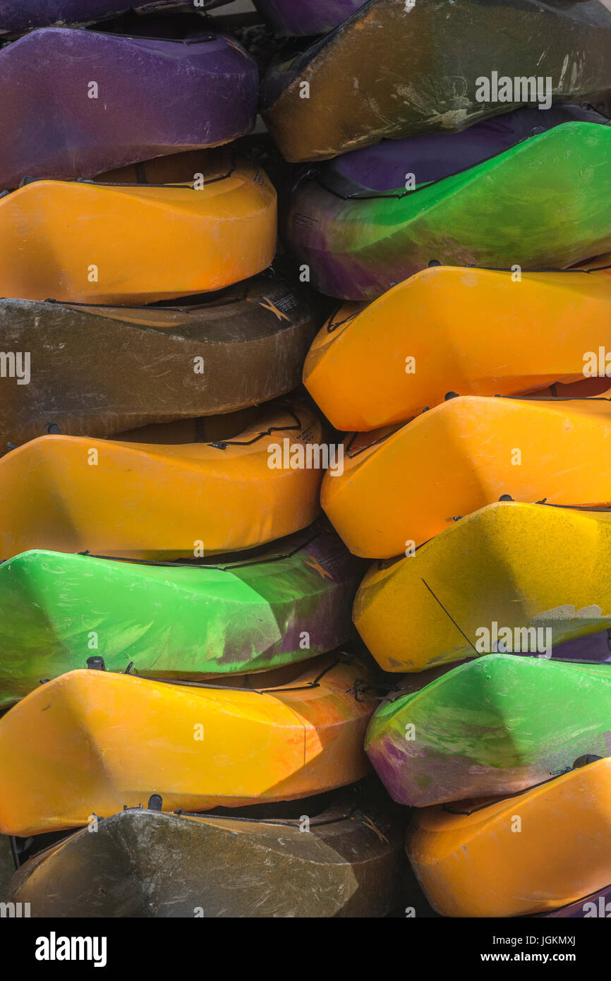 Multiple colours 'For Hire' sea kayaks in storage (actually on-end). Stock Photo