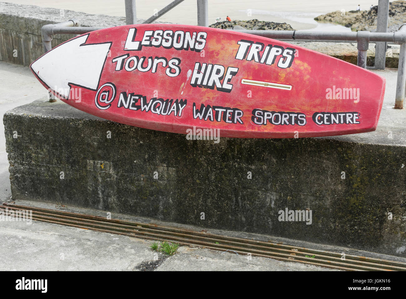 Old surfboard utilised as an advertising hoarding for a surfboard hire and surfing lessons business at Newquay harbour, Cornwall. Stock Photo