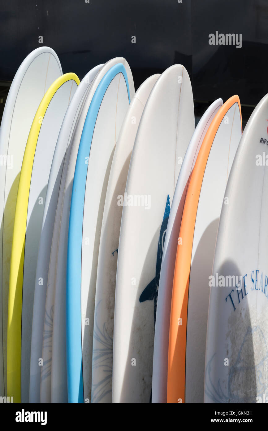 Racked display of surfboards for hire and sale at seaside town of Newquay, Cornwall - Home of Boardmasters Festival. Stock Photo