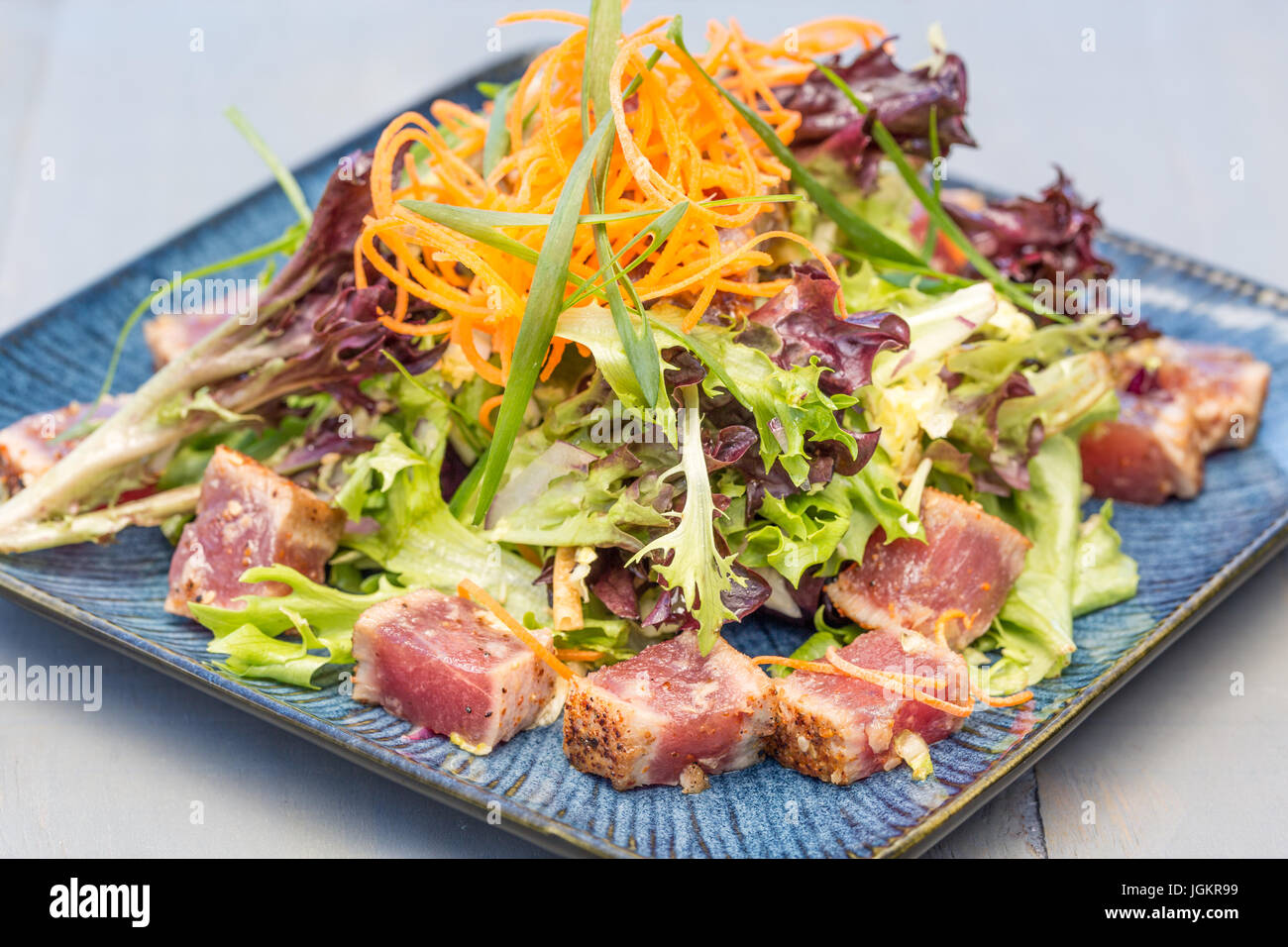 Seared ahi tuna served with mixed greens, shredded carrots and green
