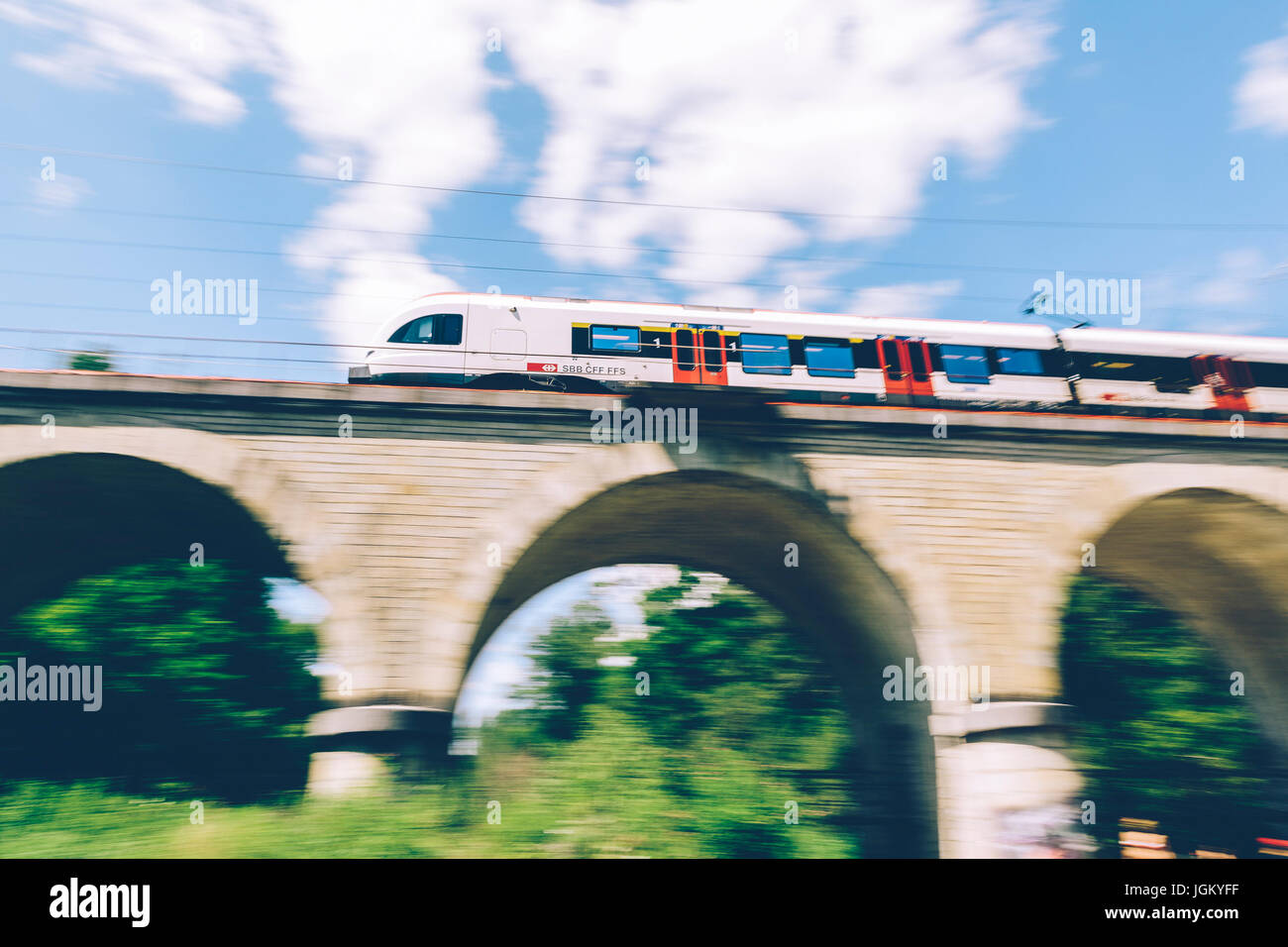 Geneva, Switzerland - June 25, 2017: Swiss regional train passing over a bridge in the Geneva Canton region, with motion blur. Stock Photo