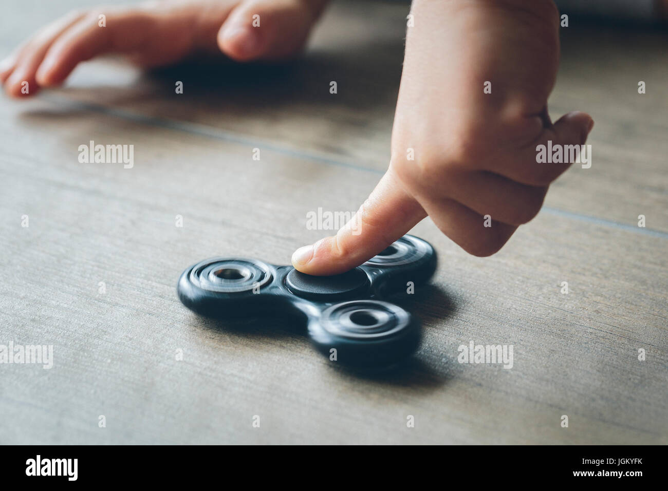 Closeup of a child's hand playing with a fidget spinner Stock Photo