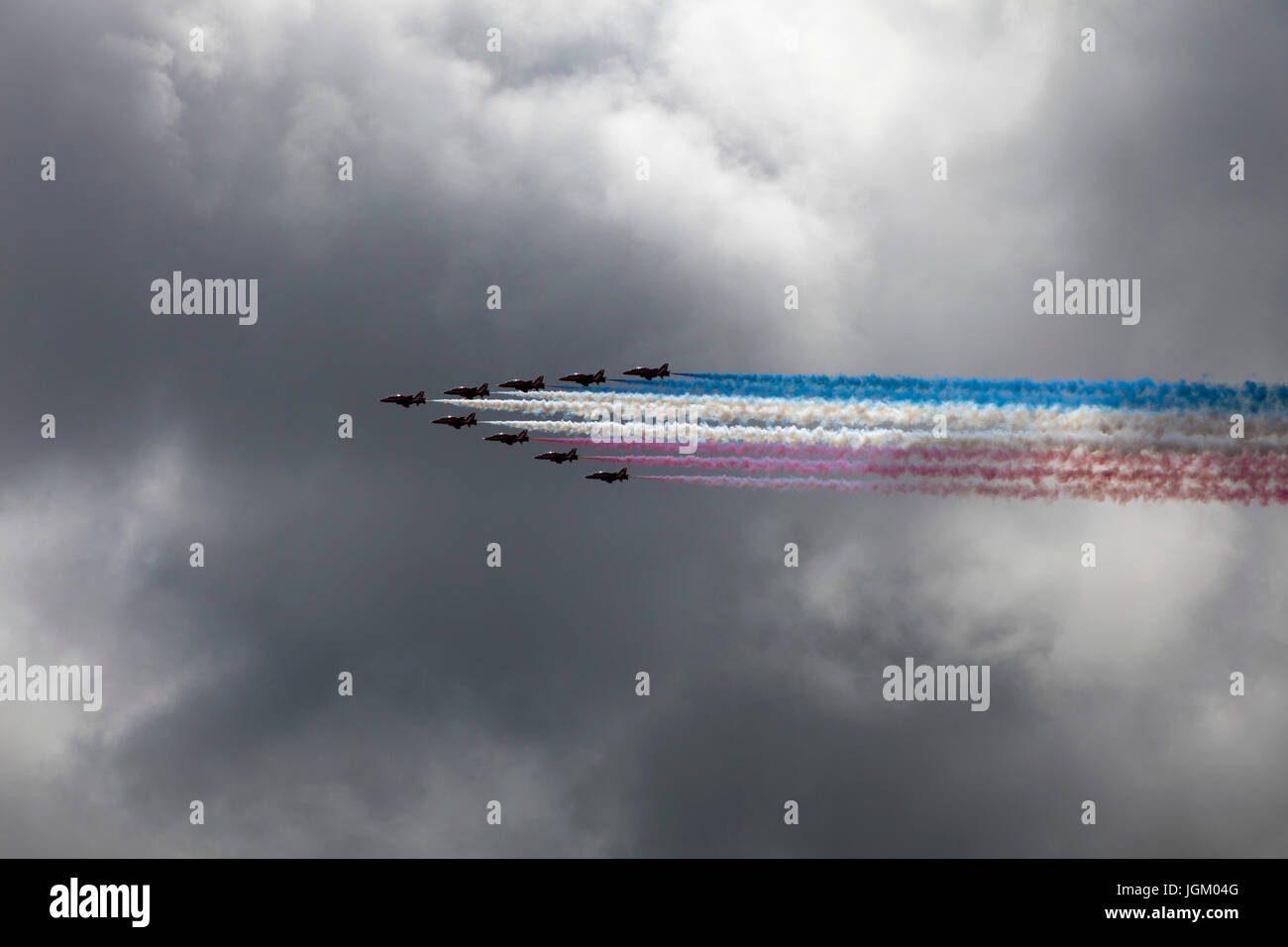 Red Arrows flypast against the backdrop of  stormy sky over Liverpool UK. Stock Photo