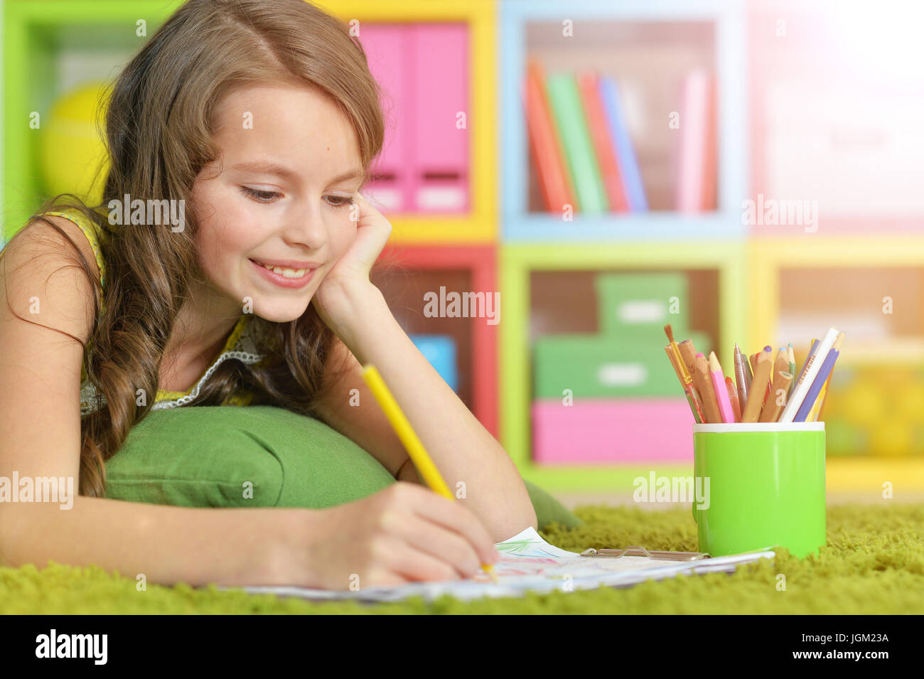 Little girl painting with pencil in her room  Stock Photo