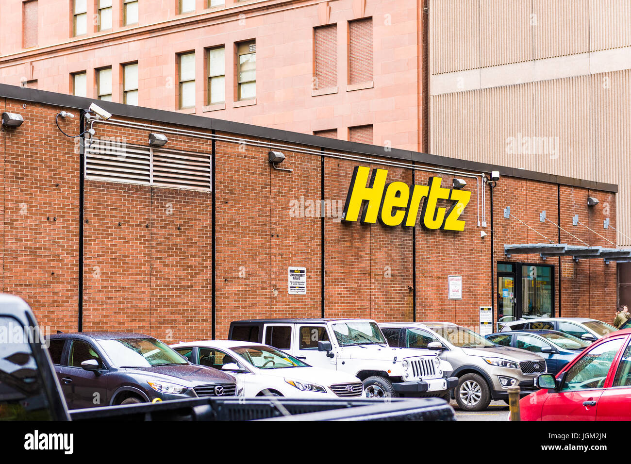 Montreal, Canada - May 26, 2017: Hertz car rental sign and brick building in downtown area of city in Quebec region Stock Photo