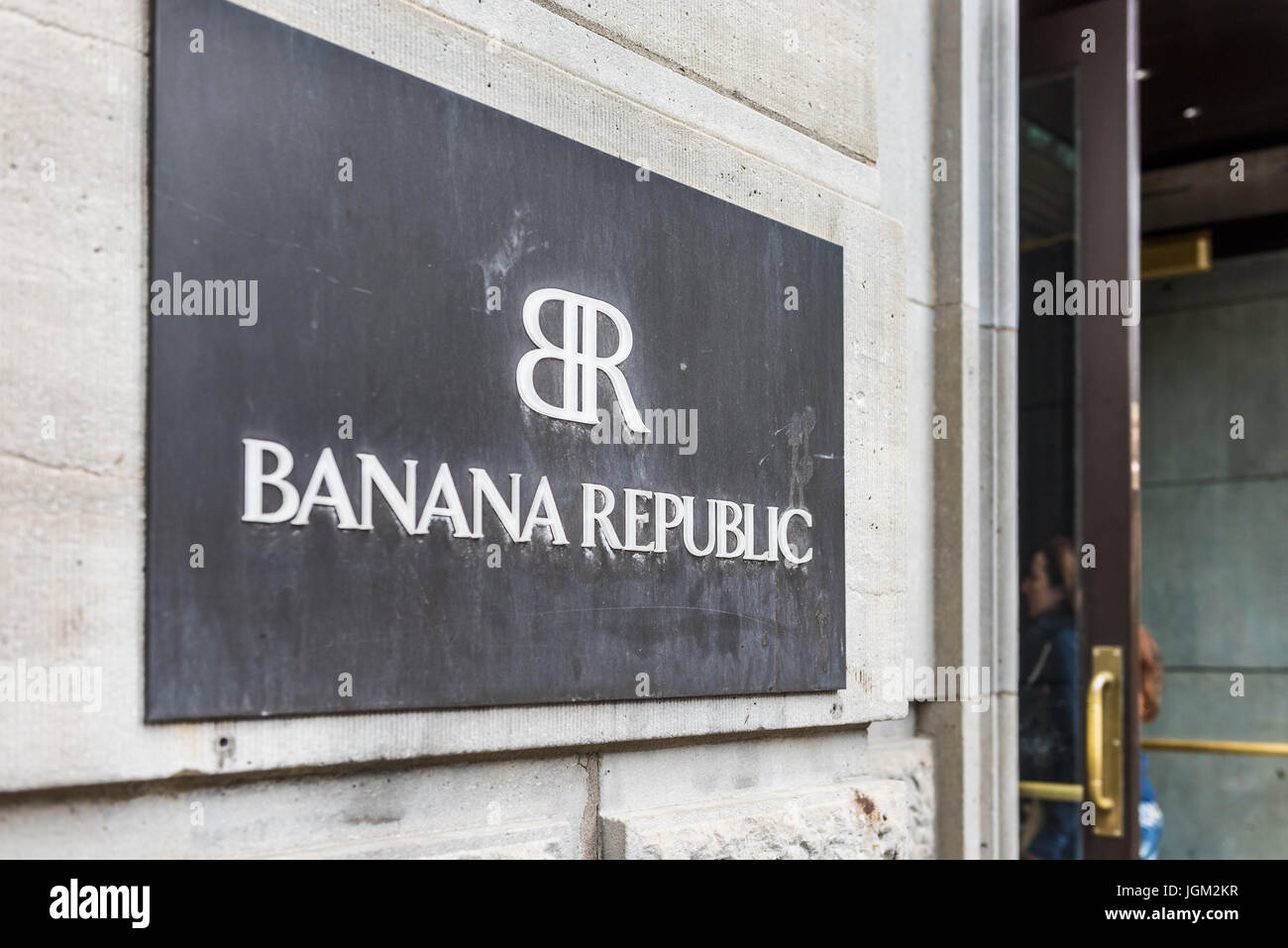 Montreal, Canada - May 26, 2017: Closeup of Banana Republic store sign with people going inside entrance door in downtown area in Quebec region Stock Photo