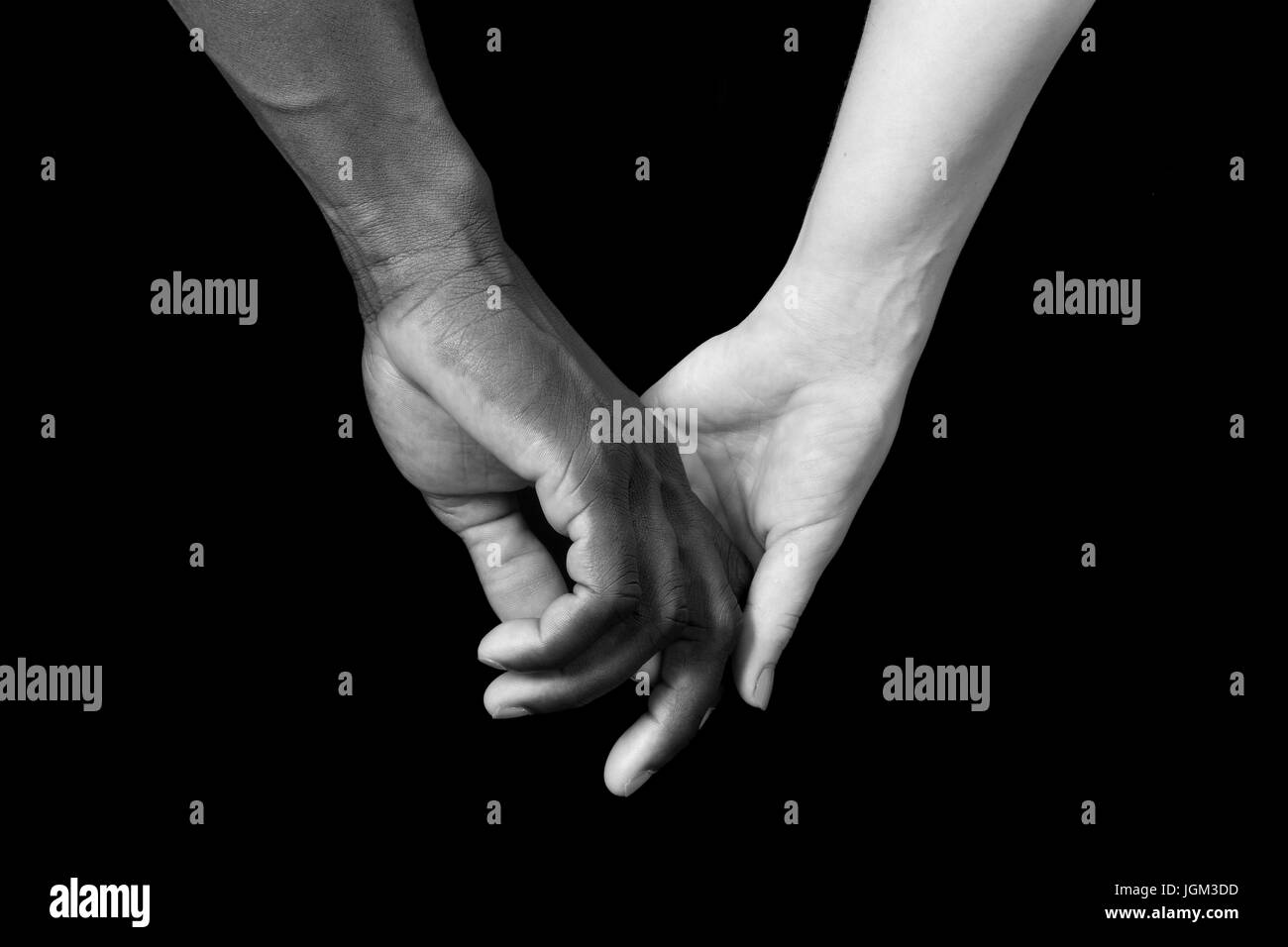 A hands of black man and white woman on black background Stock Photo