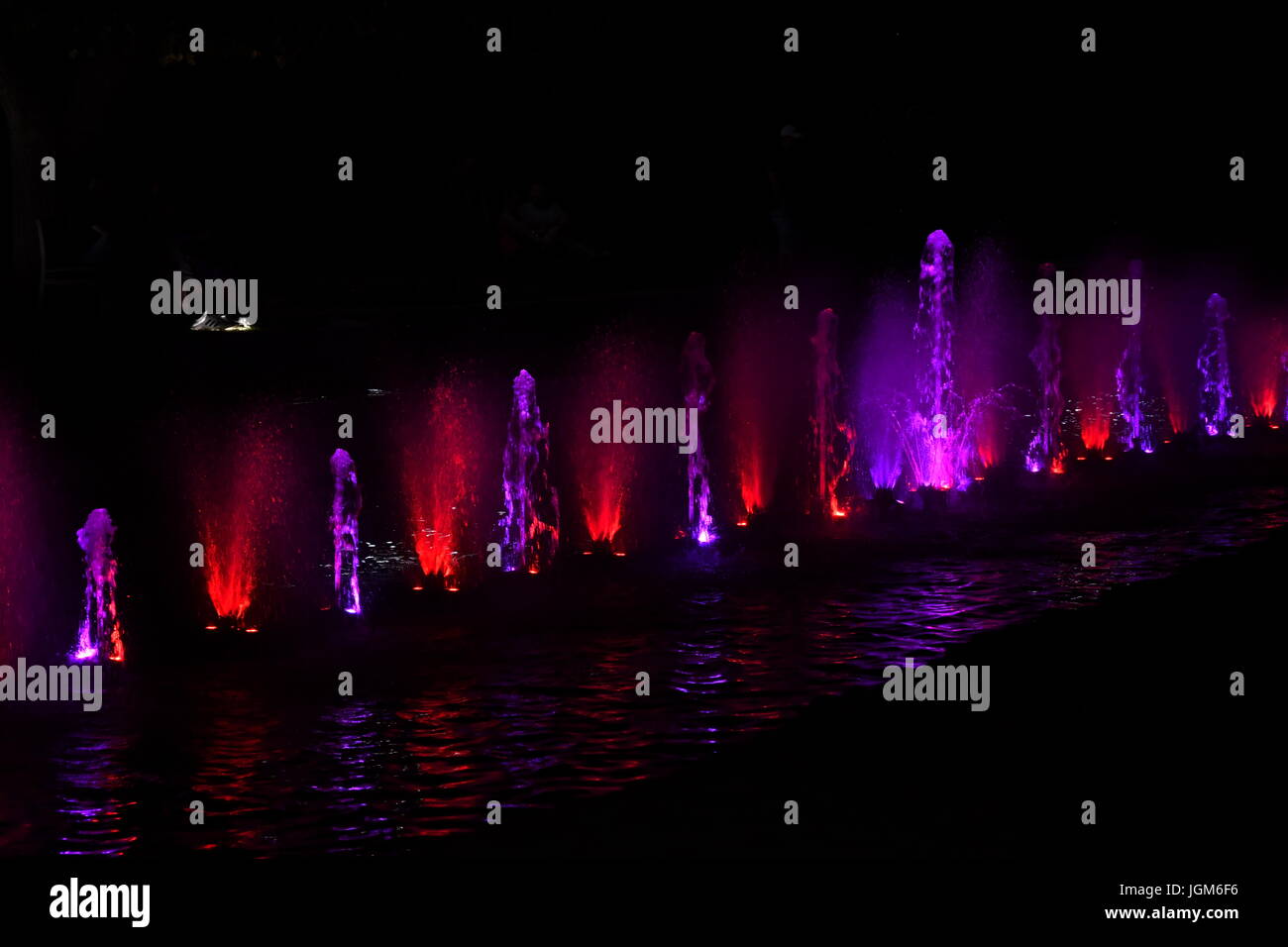 colored water fountain in the city park in the night Stock Photo - Alamy
