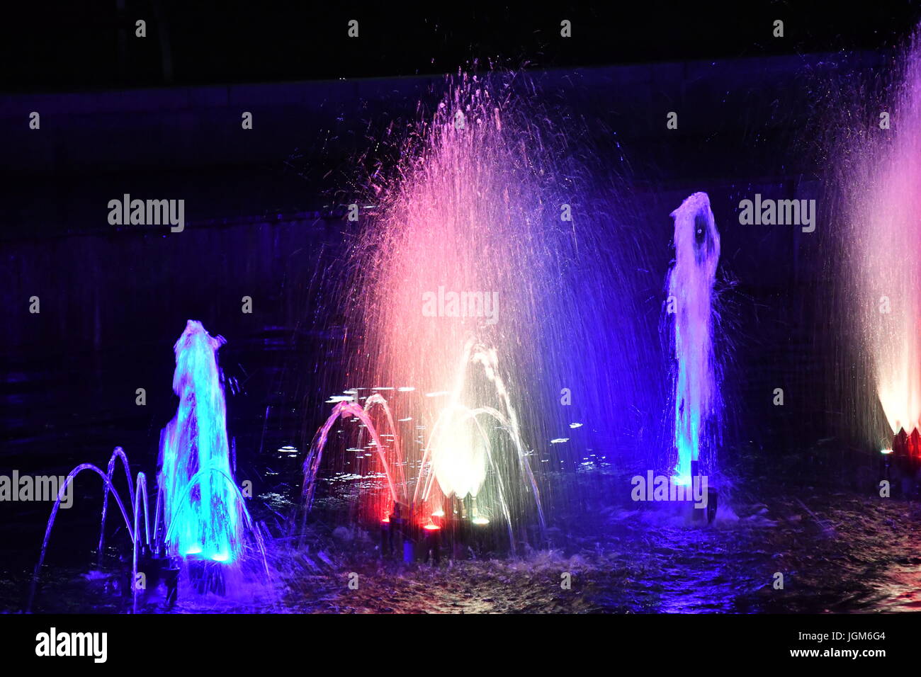 colored water fountain in the city park in the night Stock Photo - Alamy