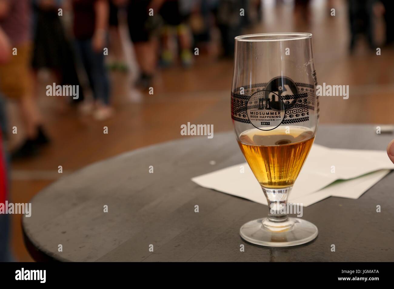 Half full glass of beer on the table at the Stonehaven Beer Festival. Stock Photo
