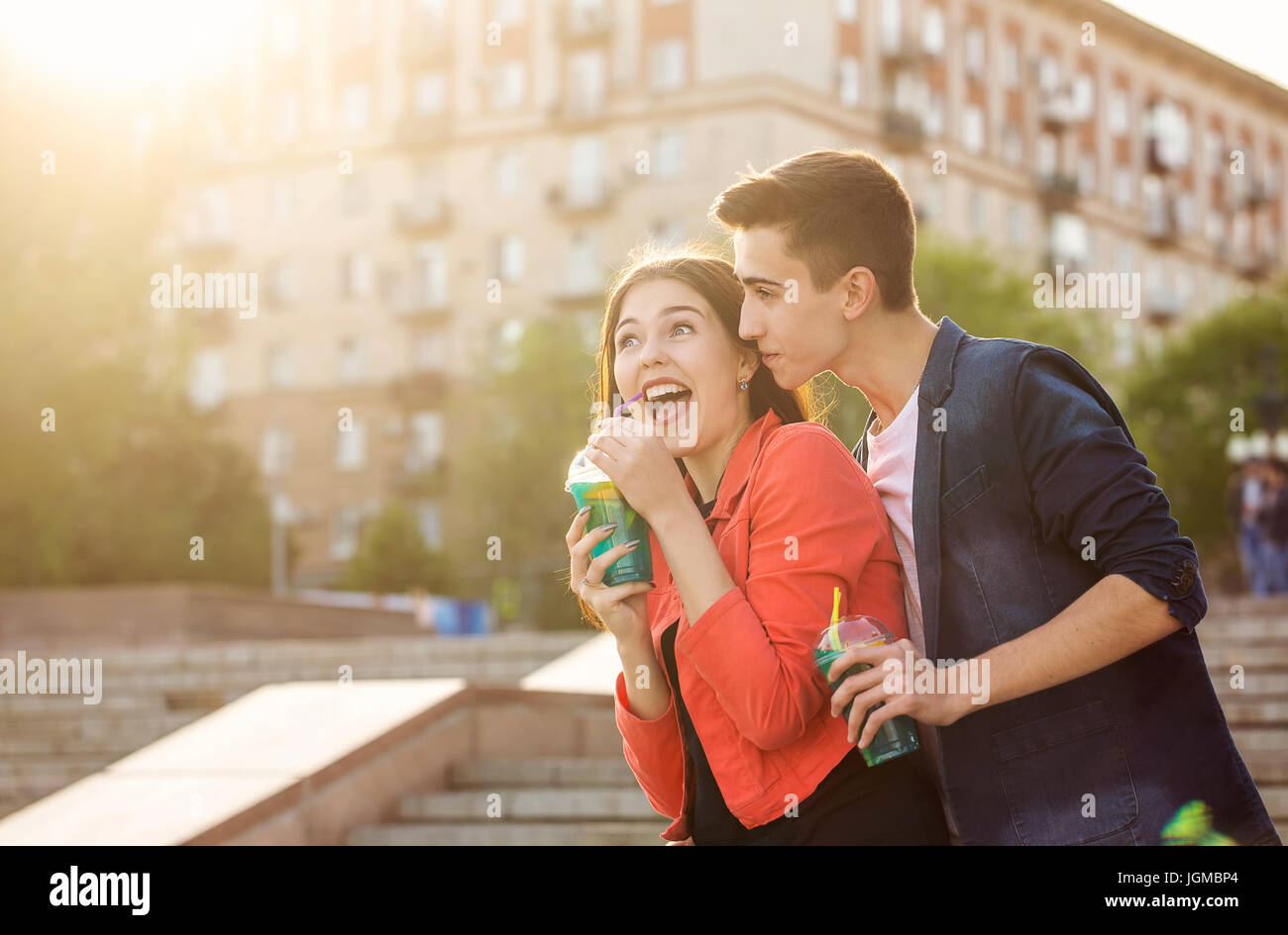 Teenagers drink fruit fresh from glasses. They are happy. A couple in love on a date. Romance of first love. Stock Photo