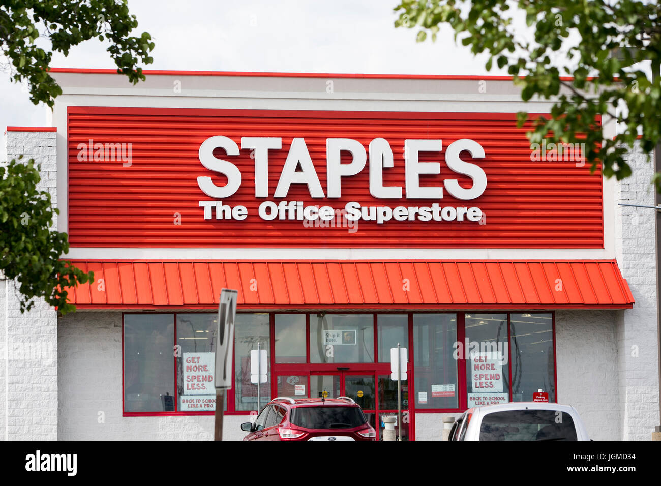 A logo sign outside of a Staples office supply retail store in Franklin
