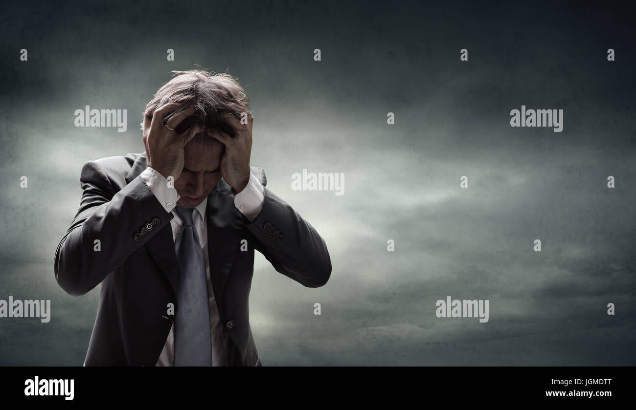 Depressed Businessman With Grunge Cloudscape Stock Photo