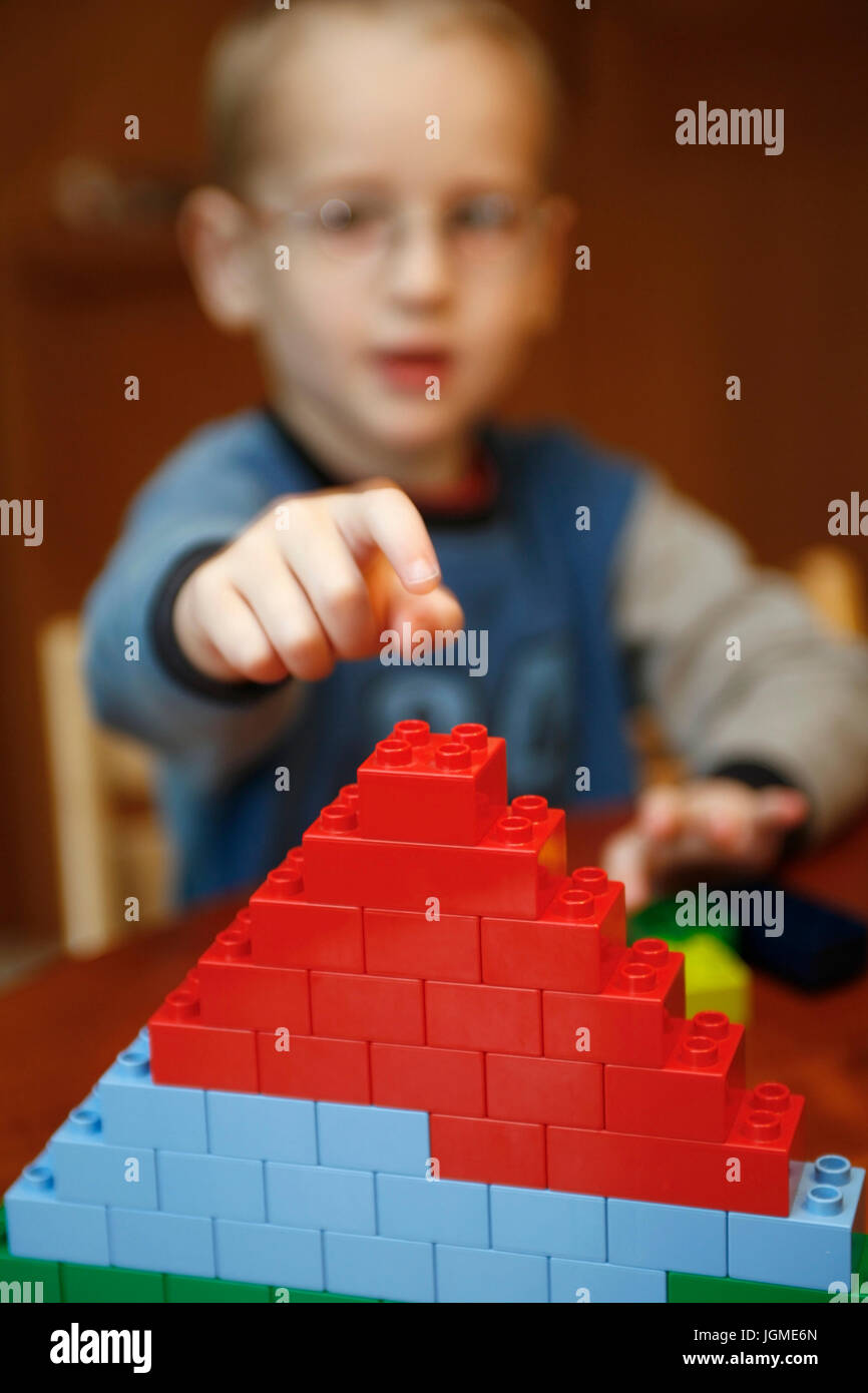Hriger boy plays with lego bricks - 4-year old bell-boy is playing with Lego bricks, 4-jaÃàhriger Junge spielt mit Legosteinen - 4-year old boy is pla Stock Photo