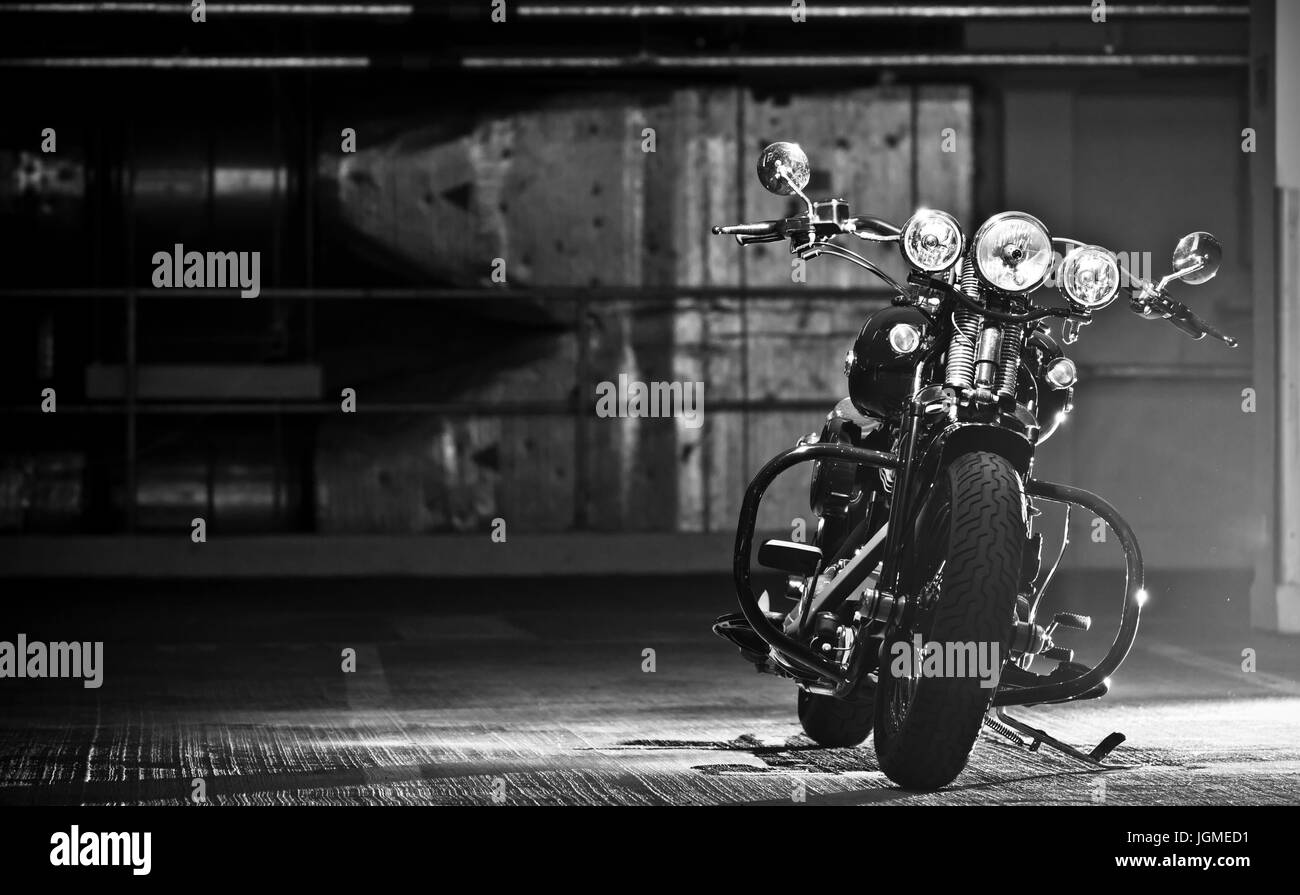 motorbike parked in the garage. Modified Harley Davidson Bobber parked in underground garage. Stock Photo