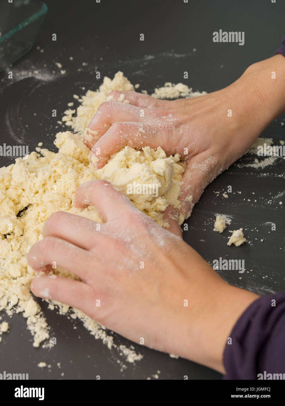 Woman kneads a dough from - Woman is baking, Frau knetet einen Teig ab - Woman is baking Stock Photo