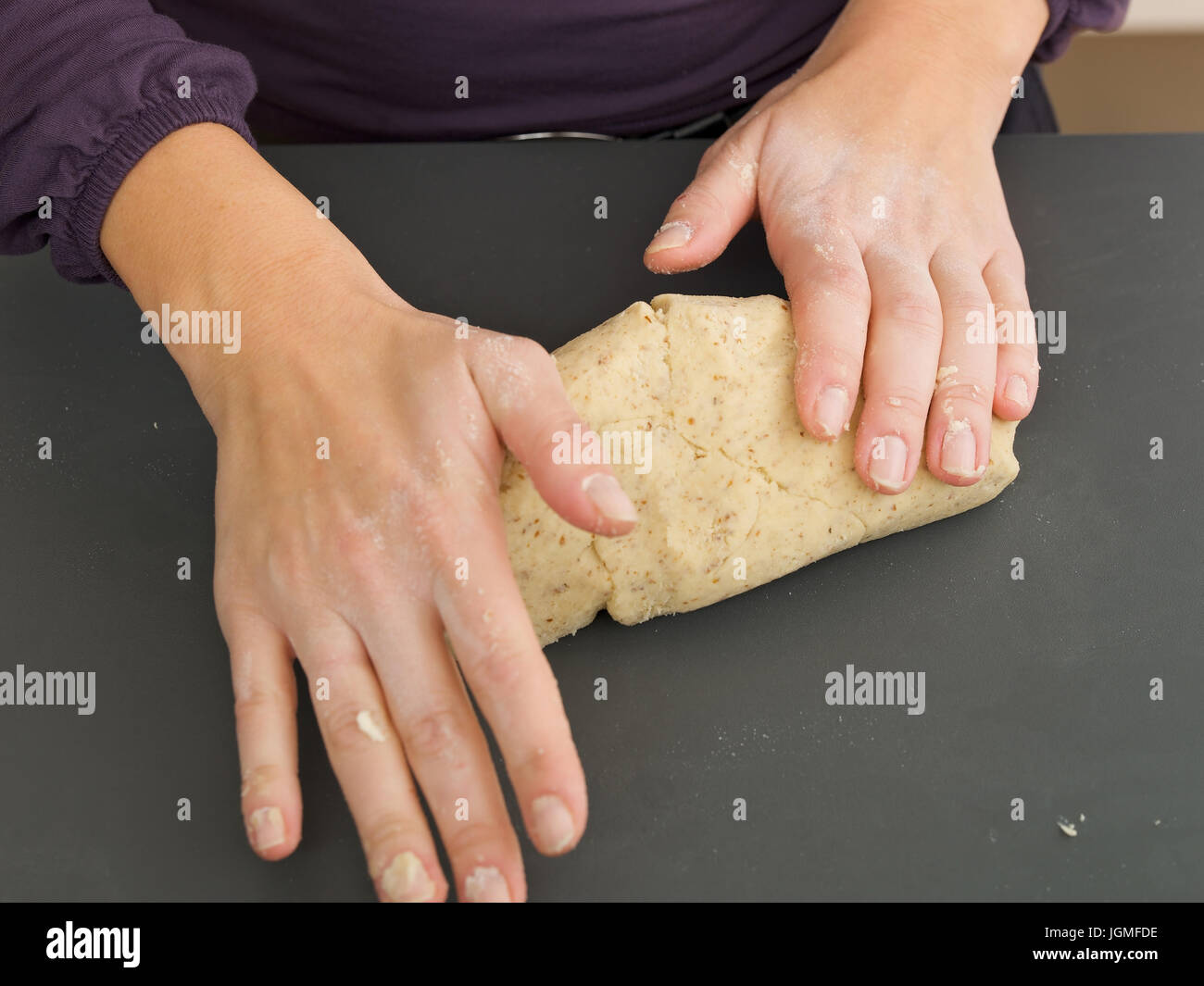 Woman prepares a biscuit dough - Woman confects a batter, Frau bereitet einen Keksteig zu - Woman confects a batter Stock Photo