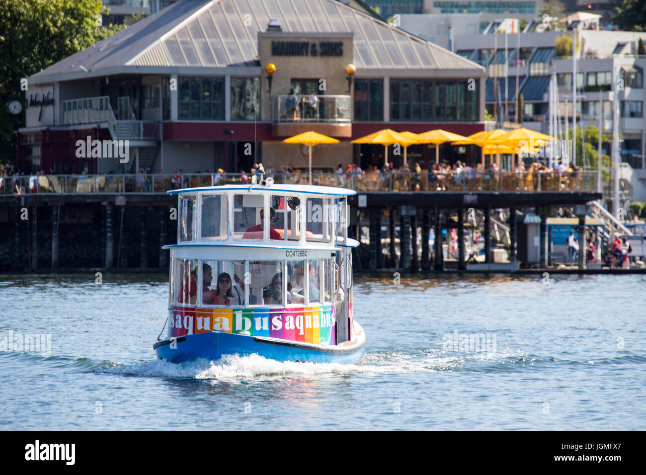 Aquabus, Tourist boat in False Creek, pulling away from Mahony & Sons Restaurant, Stamps Landing, Vancouver, Canada Stock Photo