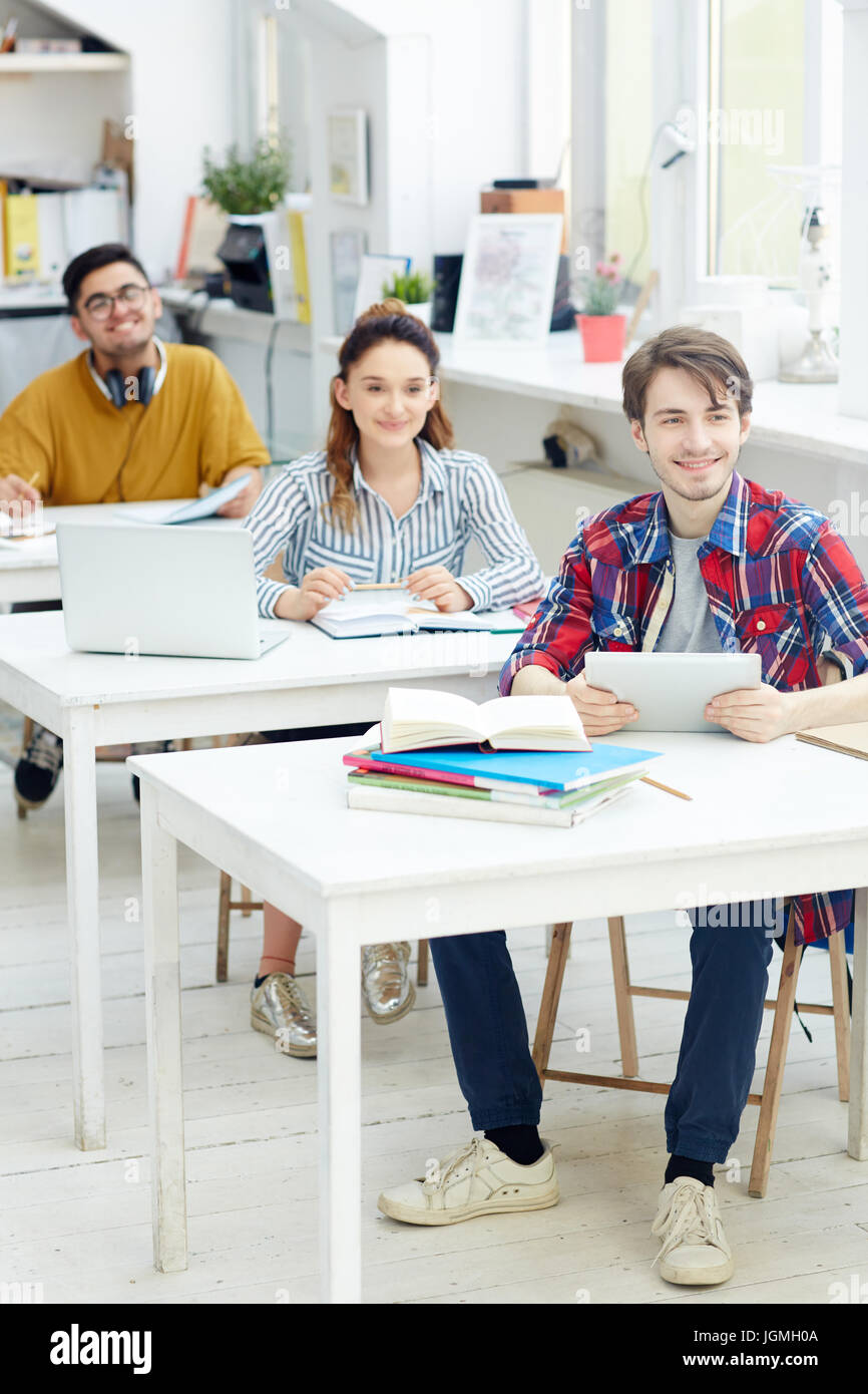 Group of college learners sitting by desks at lesson Stock Photo