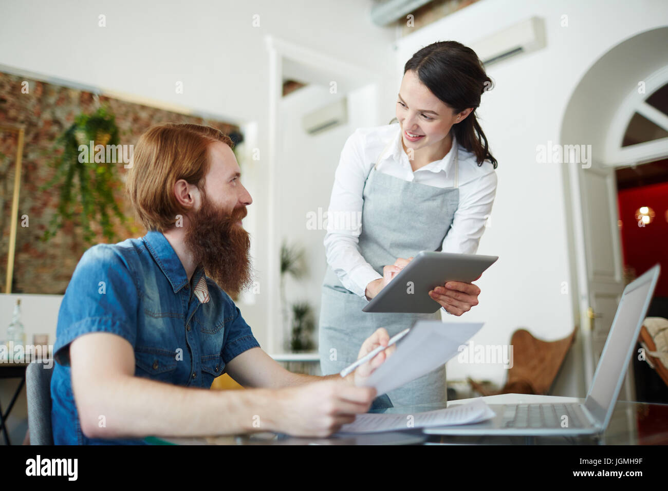 Polite waitress with touchpad helping guest to choose lunch set Stock ...