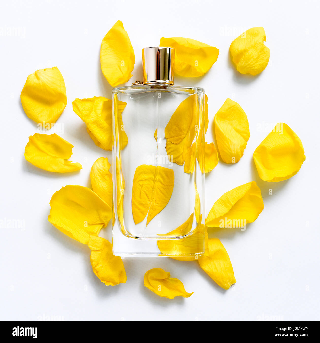 Perfume bottle with flower petals on light background. Perfumery