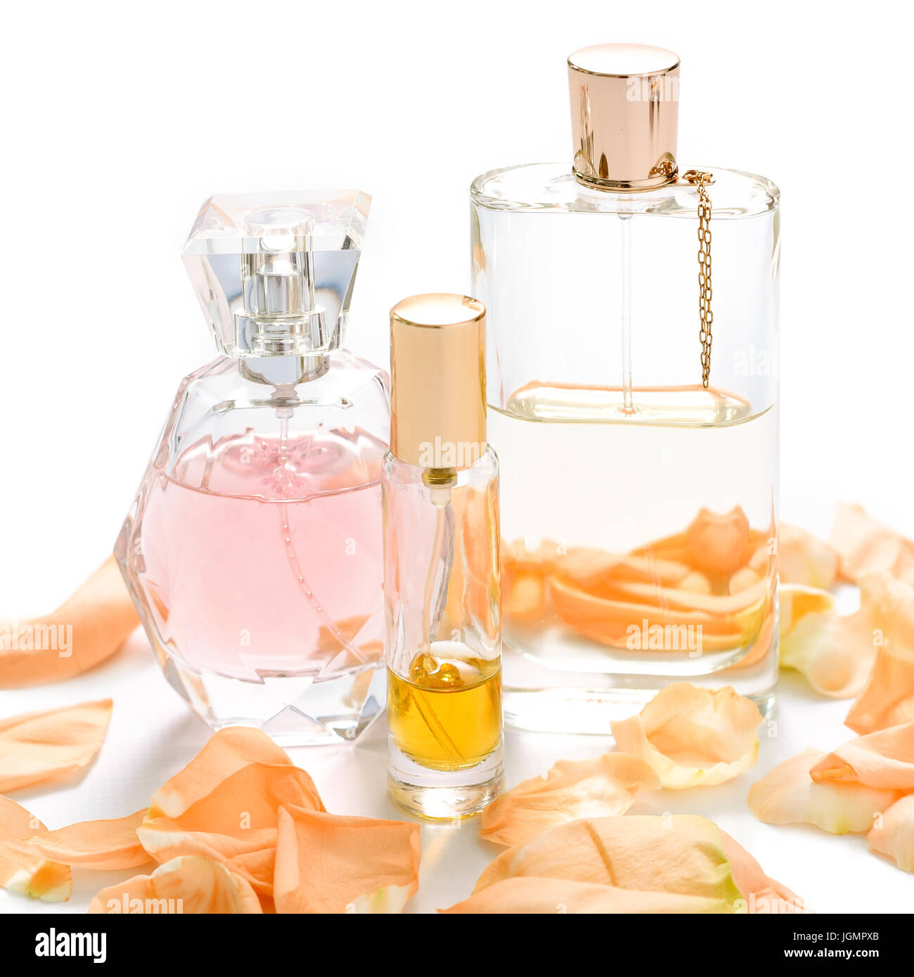 Perfume bottles with flower petals on light background. Perfumery