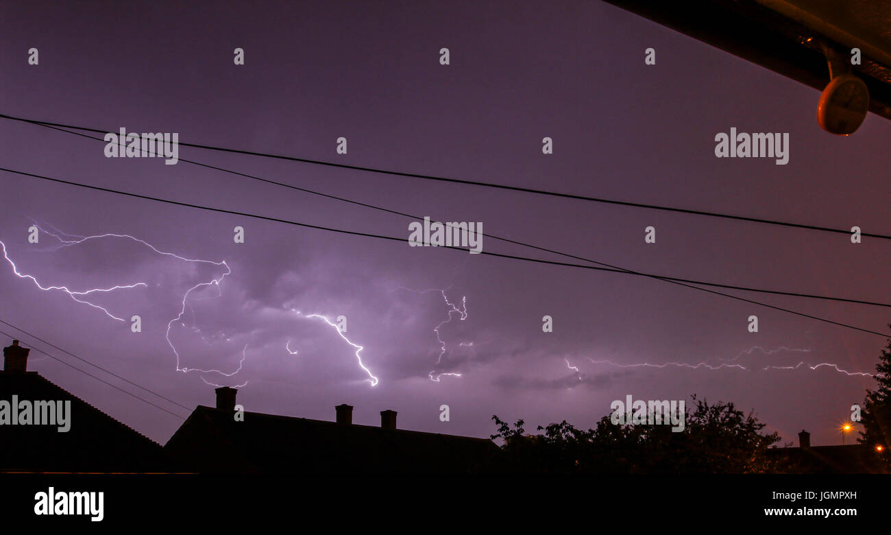 UK Weather. Thunder storm in the early hours of  morning with spectacular lightning above sleeping homes. Lound thunder and bright lightning. Stock Photo