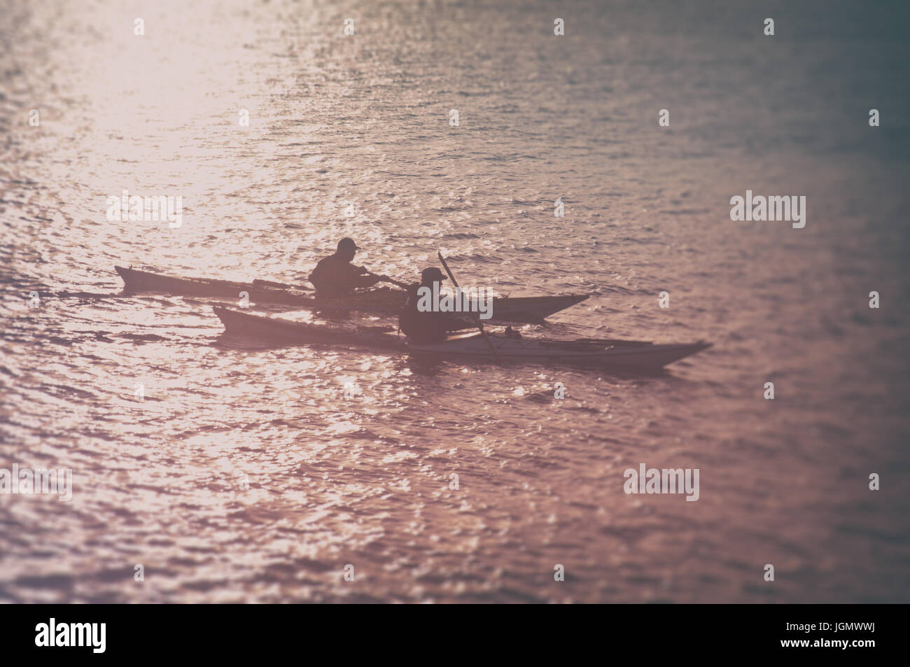 Two kayaks rowing at in sunset sea. Travel background Stock Photo